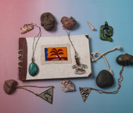 “Sea rocks and necklaces arranged around a photo album.”